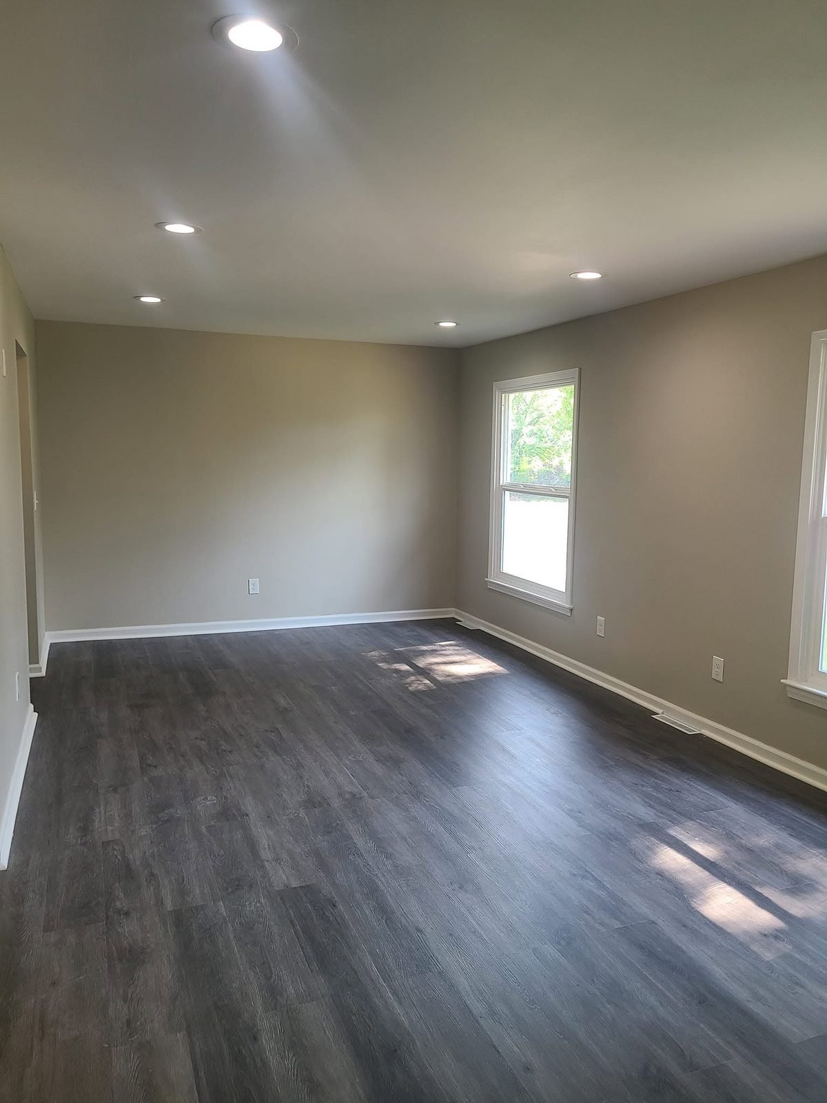 Living room with new LVP flooring and recessed lighting